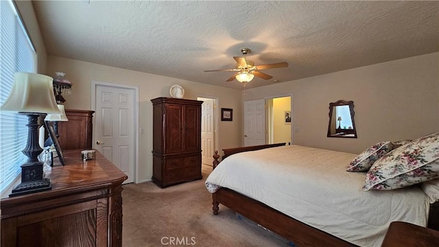 bedroom featuring light colored carpet, a textured ceiling, and a ceiling fan