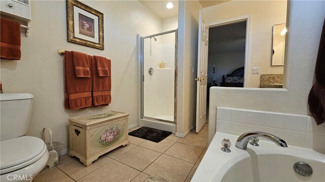 ensuite bathroom featuring a shower stall, tile patterned floors, ensuite bath, and toilet