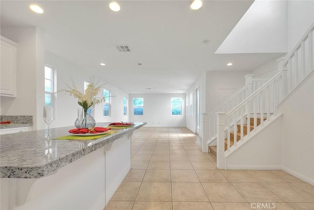 2925 E Via Terrano, Ontario, CA 91764 - kitchen with recessed lighting, light tile patterned floors, white cabinets, light stone countertops, and open floor plan