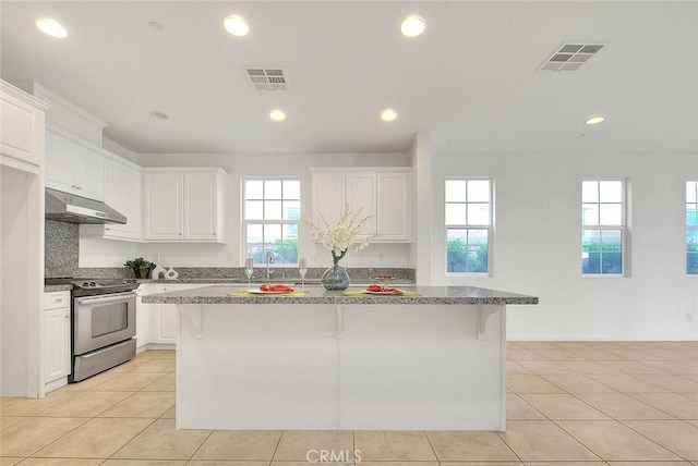 2925 E Via Terrano, Ontario, CA 91764 - kitchen featuring electric stove, under cabinet range hood, white cabinetry, a kitchen island, and light tile patterned floors