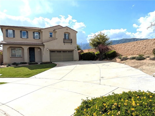 mediterranean / spanish-style home featuring driveway, an attached garage, a front yard, a tile roof, and stucco siding