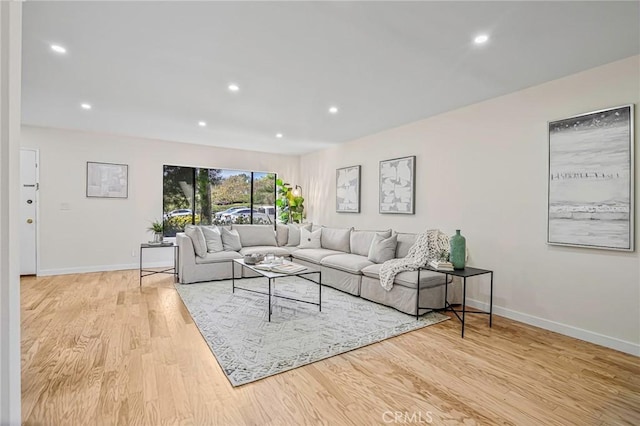 living area with recessed lighting, baseboards, and light wood finished floors