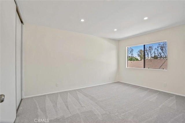 carpeted empty room with baseboards and recessed lighting