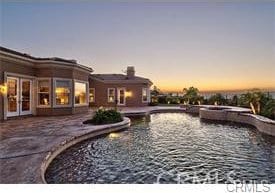 4069 Nancy Cir, Corona, CA 92881 - pool at dusk with a patio area, a pool with connected hot tub, and a fire pit
