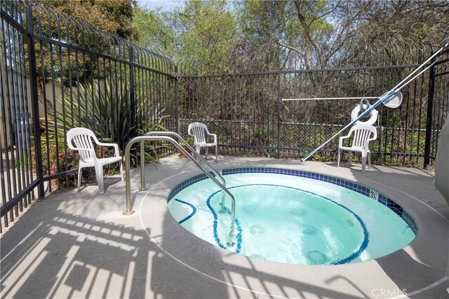 view of pool with fence and a community hot tub