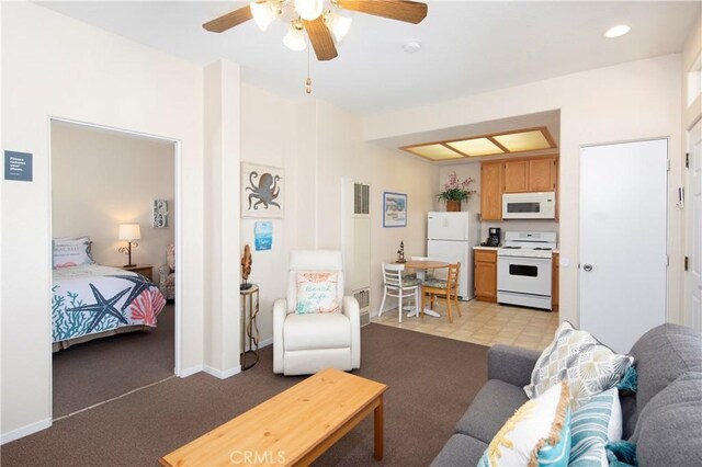 living area with light carpet, visible vents, baseboards, and a ceiling fan