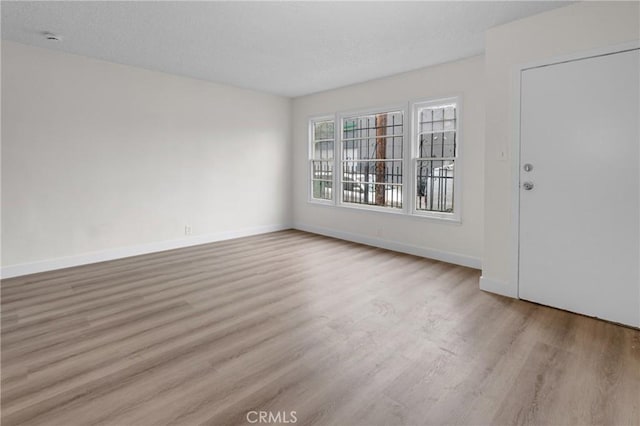 interior space featuring baseboards, wood finished floors, and a textured ceiling