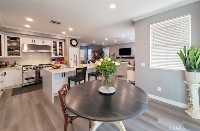 11102 Avolencia Pl, Garden Grove, CA 92840 - dining area featuring ornamental molding, recessed lighting, light wood-style flooring, baseboards, and plenty of natural light