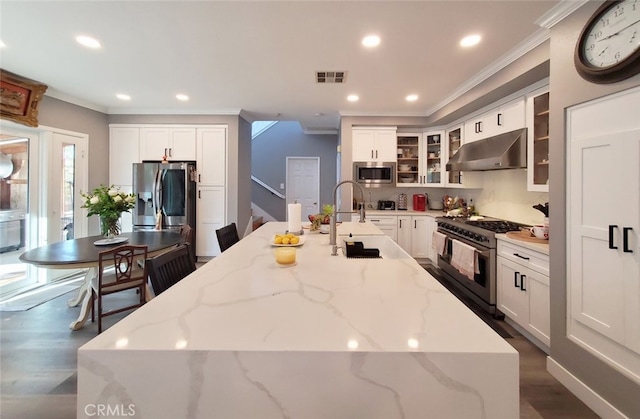11102 Avolencia Pl, Garden Grove, CA 92840 - kitchen with under cabinet range hood, stainless steel appliances, crown molding, a kitchen island with sink, and dark wood-type flooring