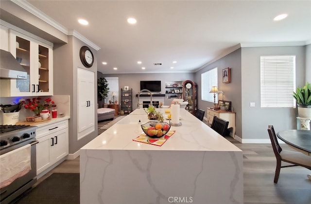 11102 Avolencia Pl, Garden Grove, CA 92840 - kitchen featuring stainless steel gas stove, ornamental molding, recessed lighting, glass insert cabinets, and light stone countertops