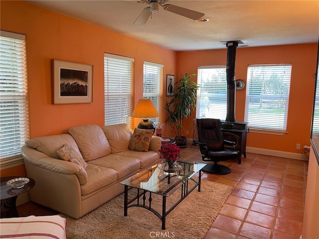 7371 Mcclure Ave, Gerber, CA 96035 - living area with a wood stove, ceiling fan, baseboards, and light tile patterned floors