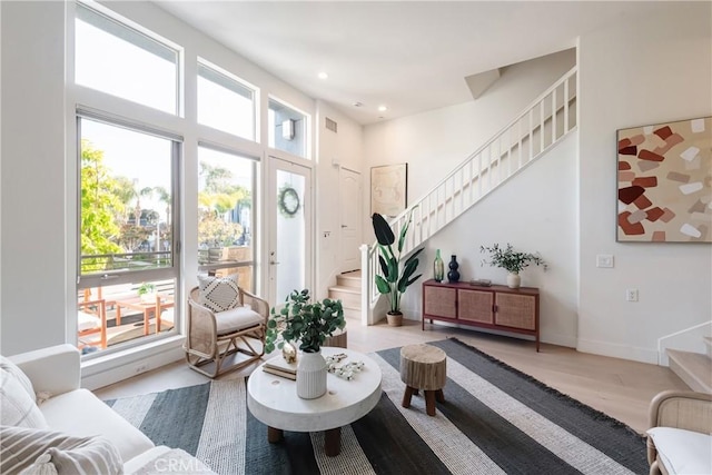 living area featuring baseboards, recessed lighting, wood finished floors, and stairway