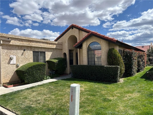 view of front facade with stucco siding and a front lawn