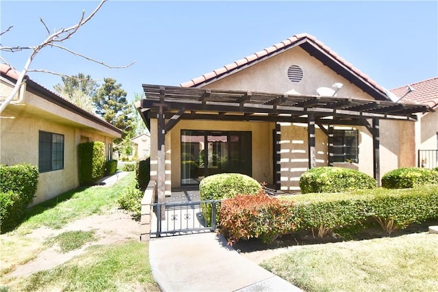 exterior space with a pergola, a tiled roof, a gate, and stucco siding