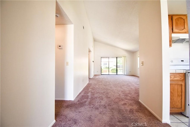 corridor featuring baseboards, high vaulted ceiling, and light colored carpet