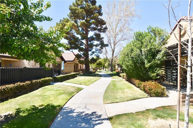 view of home's community featuring fence and a yard