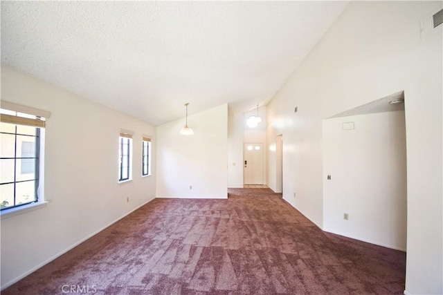 carpeted spare room with high vaulted ceiling