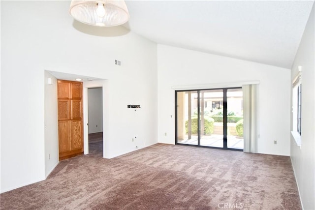 spare room with plenty of natural light, high vaulted ceiling, visible vents, and carpet