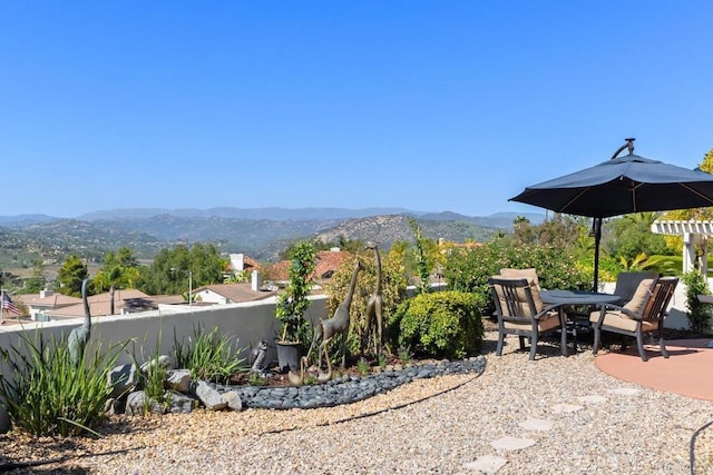 view of patio with a mountain view and fence
