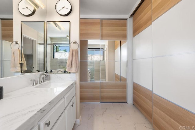 bathroom featuring marble look tile flooring and vanity