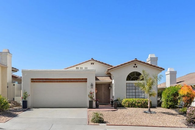 13336 Corte De Comares, San Diego, CA 92128 - mediterranean / spanish home with an attached garage, driveway, stucco siding, and a tiled roof