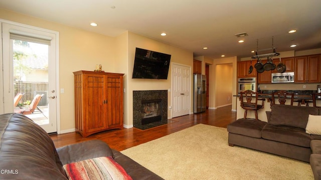 living room featuring visible vents, recessed lighting, dark wood-style flooring, and a fireplace with flush hearth