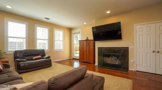 living area featuring recessed lighting, visible vents, wood finished floors, and a fireplace