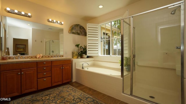 full bath featuring a sink, double vanity, a stall shower, and a bath