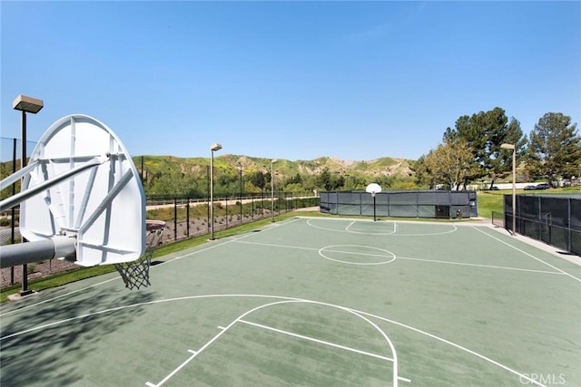 view of basketball court with a mountain view, fence, and community basketball court