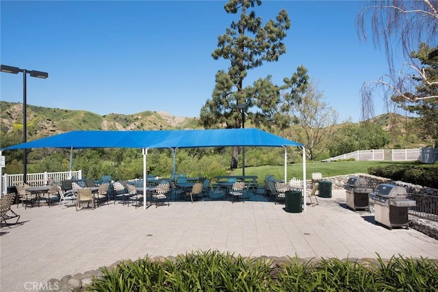 view of patio featuring a mountain view, area for grilling, and fence