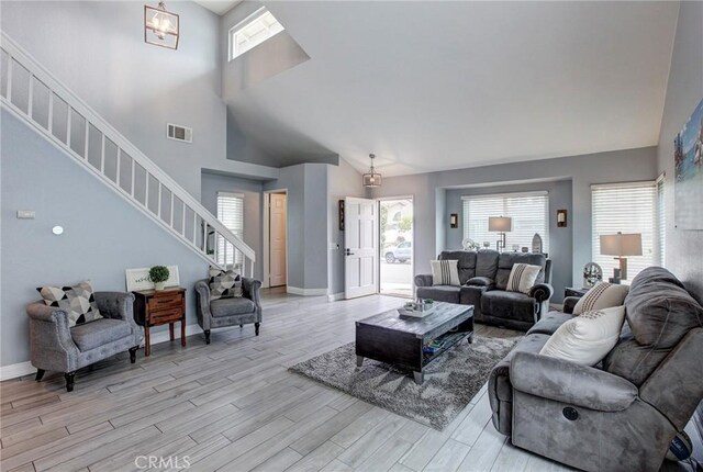 living room with light wood-type flooring, visible vents, and a healthy amount of sunlight