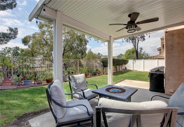 view of patio / terrace with area for grilling, ceiling fan, a fenced backyard, and an outdoor fire pit