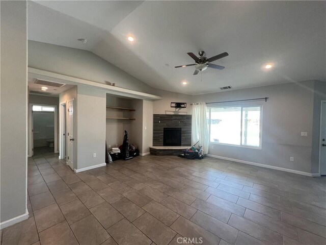 17238 Danbury Ave, Hesperia, CA 92345 - unfurnished living room featuring vaulted ceiling, baseboards, visible vents, a ceiling fan, and a stone fireplace