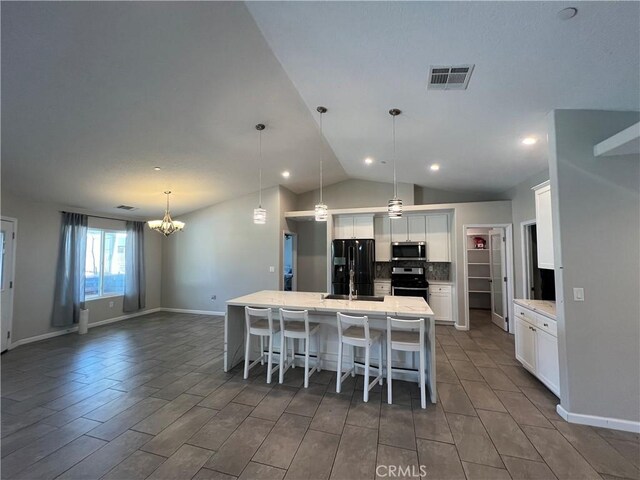 17238 Danbury Ave, Hesperia, CA 92345 - kitchen with an island with sink, a chandelier, white cabinetry, stainless steel appliances, and visible vents