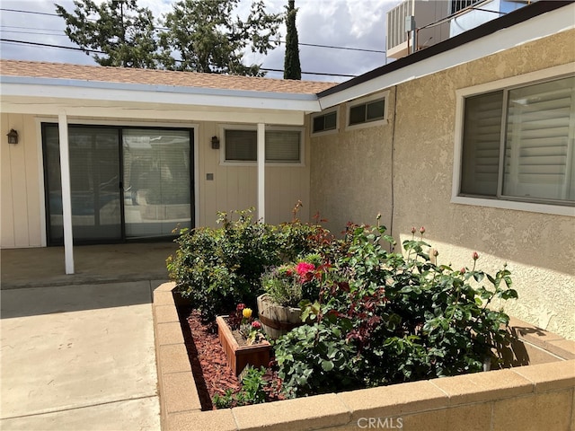 56707 Desert Gold Dr, Yucca Valley, CA 92284 - property entrance with a shingled roof, a patio area, and stucco siding