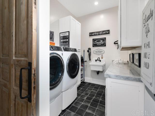 2255 Via Dulcea, Fallbrook, CA 92028 - washroom featuring independent washer and dryer, cabinet space, dark tile patterned floors, and recessed lighting