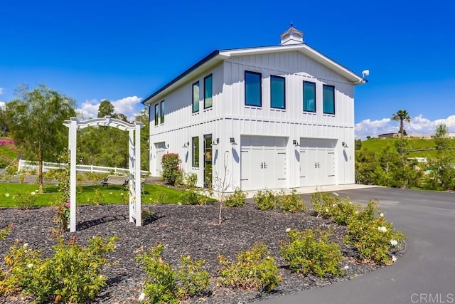 2255 Via Dulcea, Fallbrook, CA 92028 - view of front of house with board and batten siding, an attached garage, and asphalt driveway