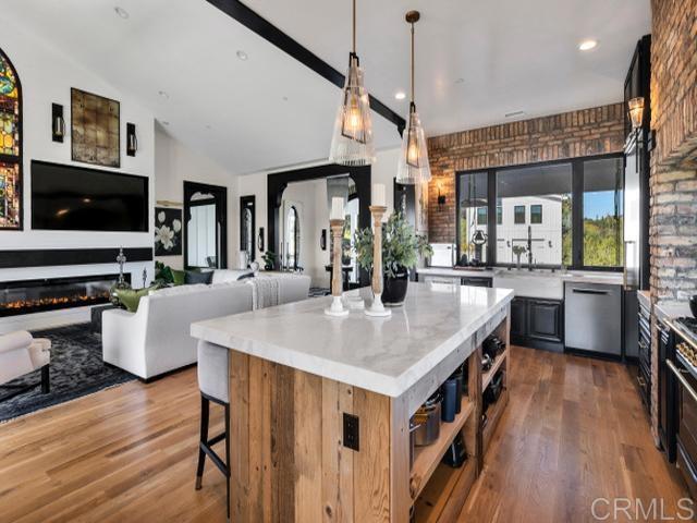2255 Via Dulcea, Fallbrook, CA 92028 - kitchen with dishwasher, a kitchen breakfast bar, dark wood-style flooring, a kitchen island, and hanging light fixtures