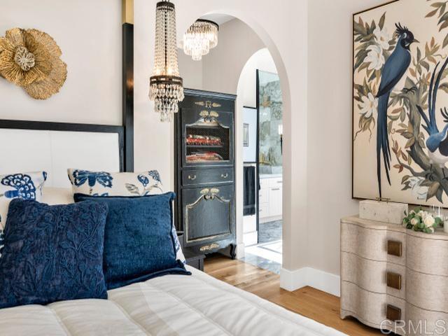 2255 Via Dulcea, Fallbrook, CA 92028 - bedroom featuring a chandelier, arched walkways, and wood finished floors