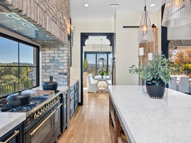 2255 Via Dulcea, Fallbrook, CA 92028 - kitchen with range with two ovens, light countertops, light wood finished floors, a chandelier, and healthy amount of natural light