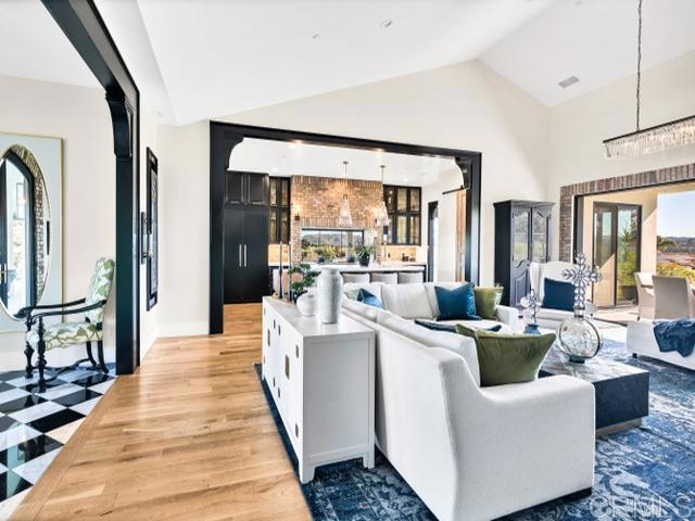 2255 Via Dulcea, Fallbrook, CA 92028 - living area with lofted ceiling, light wood-style flooring, and a chandelier