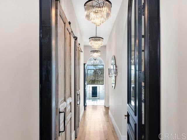 2255 Via Dulcea, Fallbrook, CA 92028 - hall featuring a barn door, a chandelier, and light wood-type flooring