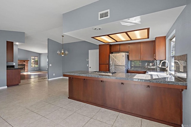 kitchen featuring a brick fireplace, tile counters, visible vents, and stainless steel appliances