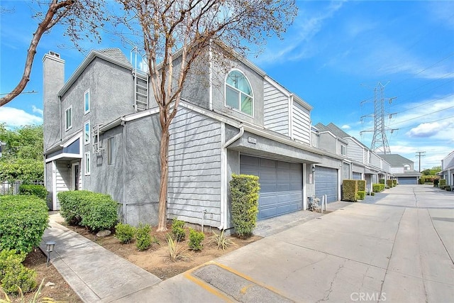 view of side of property with an attached garage and concrete driveway
