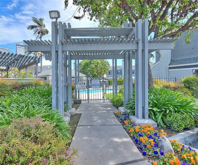 exterior space featuring a community pool, fence, and a pergola