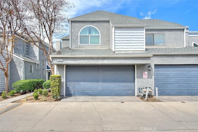 view of front of property featuring an attached garage, concrete driveway, and stucco siding