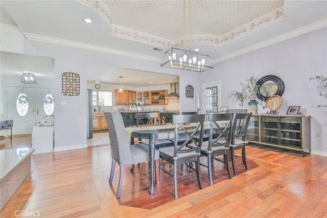 13720 Woodcock Ave, Sylmar, CA 91342 - dining room with light wood finished floors, a chandelier, ornamental molding, a raised ceiling, and baseboards