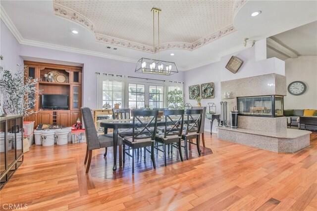 13720 Woodcock Ave, Sylmar, CA 91342 - dining space featuring high vaulted ceiling, a tray ceiling, light wood-type flooring, a chandelier, and crown molding
