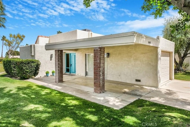 1692 Fairway Cir, Palm Springs, CA 92264 - back of house with a garage, a lawn, concrete driveway, and stucco siding