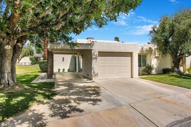 1692 Fairway Cir, Palm Springs, CA 92264 - view of front of house featuring stucco siding, a front lawn, driveway, and a garage